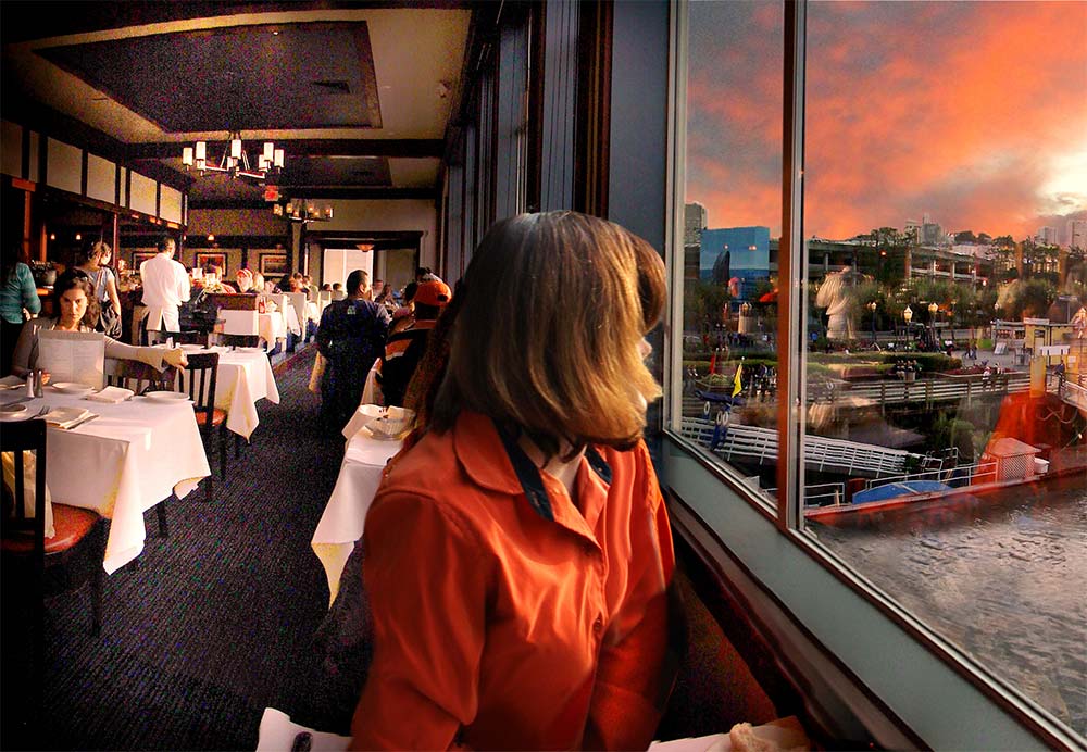 Woman watching the sunset from Fog Harbor dining room