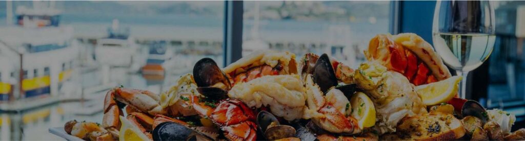 Seafood assortment and a wine glass in front of a window