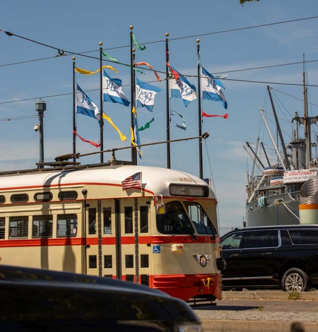 Pier 39 flags with vehicles in front
