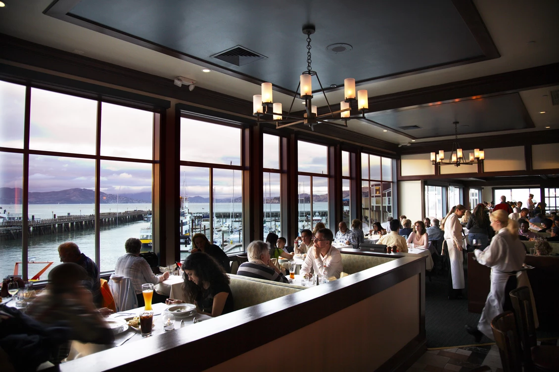 The bustling Fog Harbor dining room at Pier 39, overlooking the beautiful waterfront views of the Bay Area.